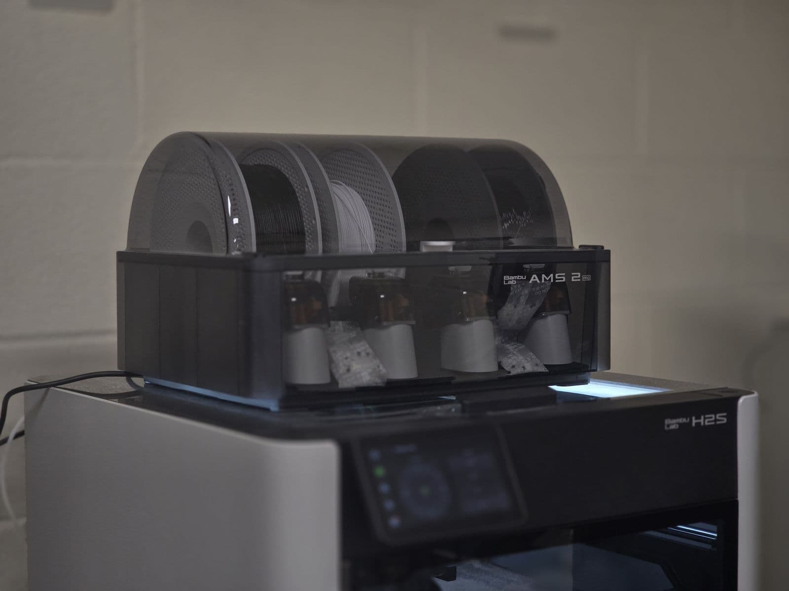 Bambu Lab H2S 3D printer with its AMS filament system loaded with several spools